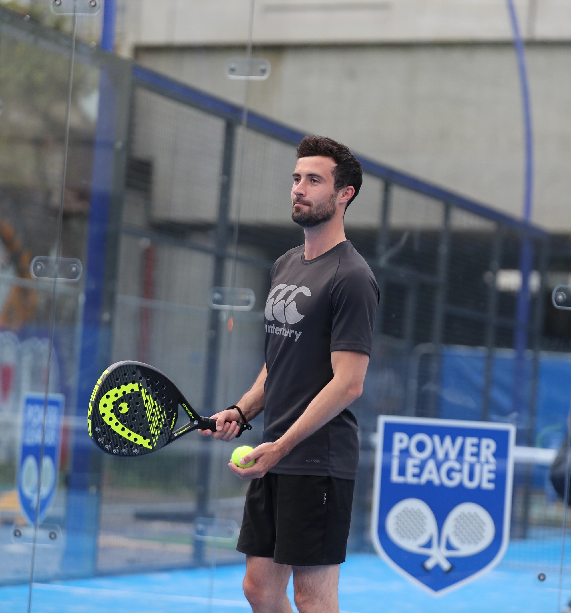 Man getting ready to serve whilst playing padel