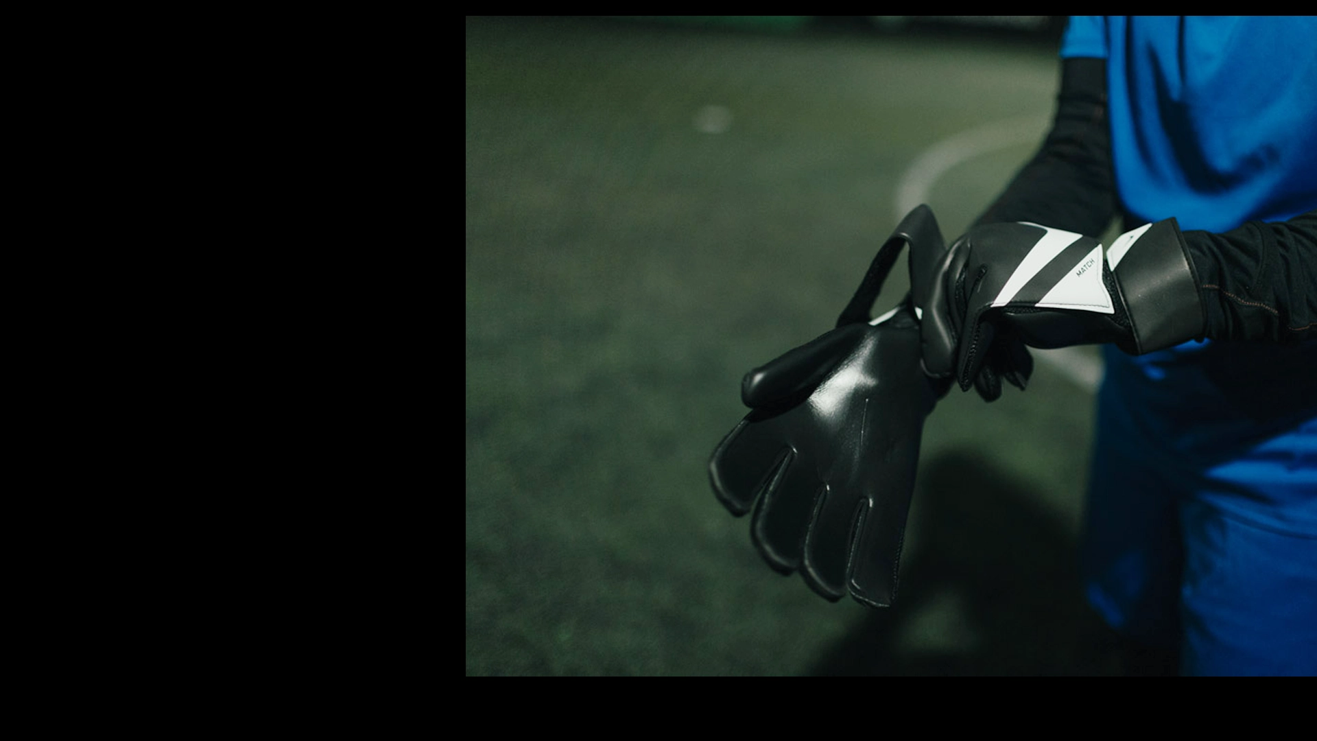 A person in a blue sports outfit is putting on black football goalkeeper gloves on a dimly lit soccer field. The ground, covered in artificial turf, features a white line in the background. Slightly cropped out of the frame, the scene almost feels like they’re preparing for more than just legal stuff. © Powerleague
