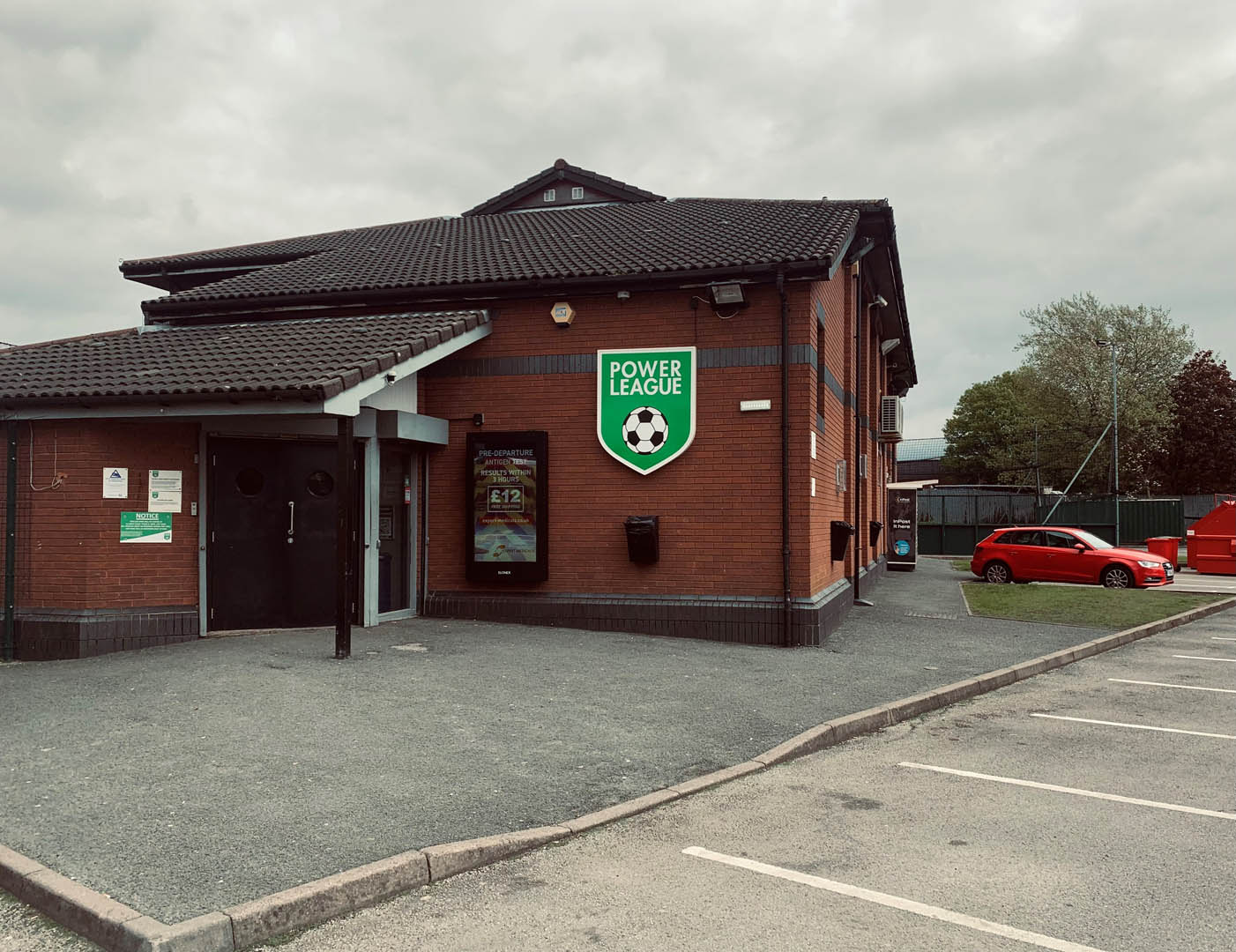 A two-story brick building with a black roof features a 