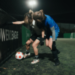 Two women playing football.